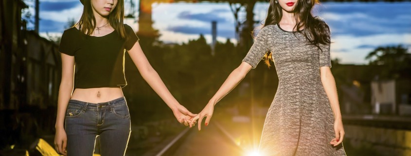 Due amiche che camminano tenendosi la mano,