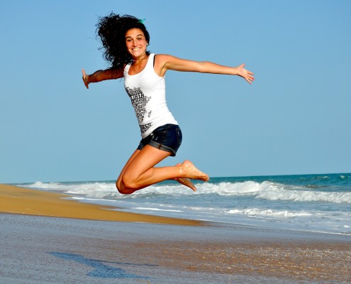 Donna al mare che salta felice
