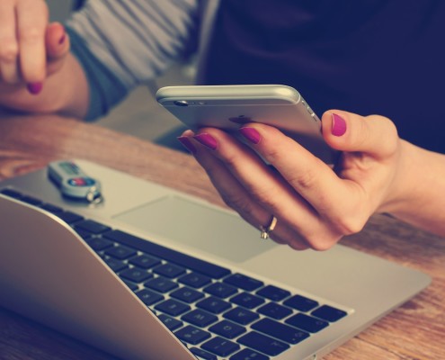 La mano di una donna che legge un messaggio davanti al pc