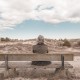 Un uomo che aspetta su una panchina, davanti ad un orizzonte infinito.