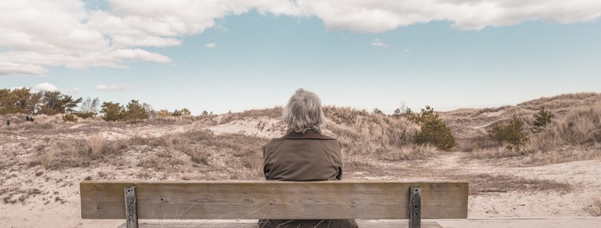 Un uomo che aspetta su una panchina, davanti ad un orizzonte infinito.