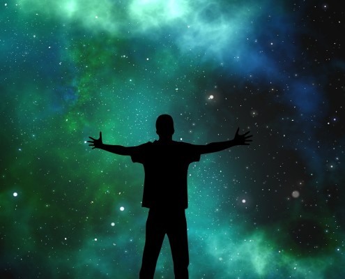Un uomo che apre le braccia osservando un cielo di stelle luminose